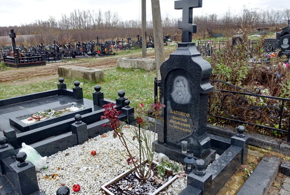 Гранитный памятник в православном стиле с компактным цветником